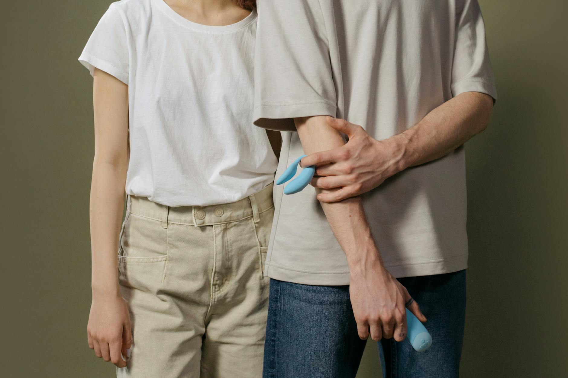 Couple holding a vibrator together, representing trust and intimacy during recovery