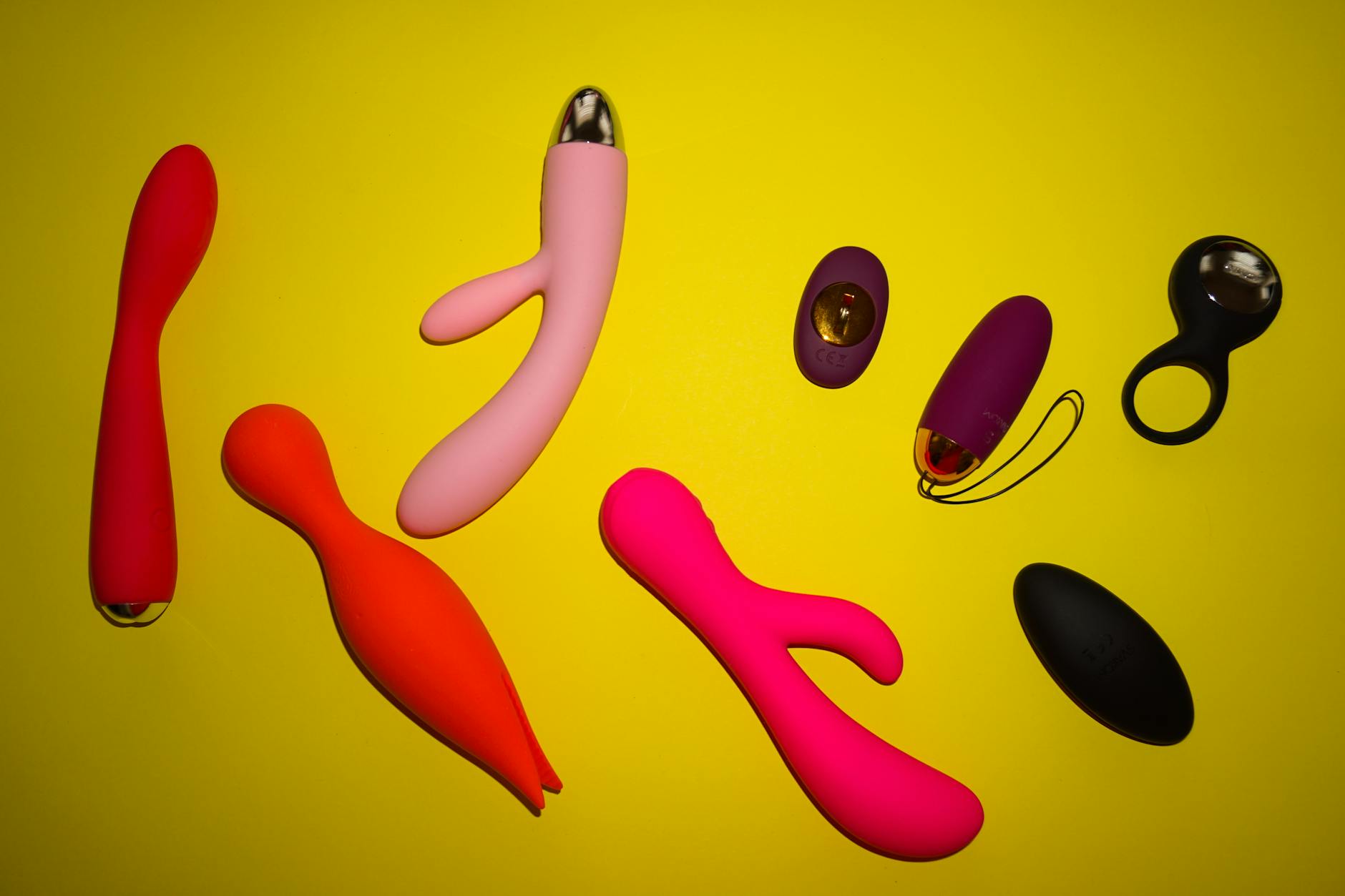 Vibrador de silicona amarilla rodeado de plátanos en fondo amarillo brillante