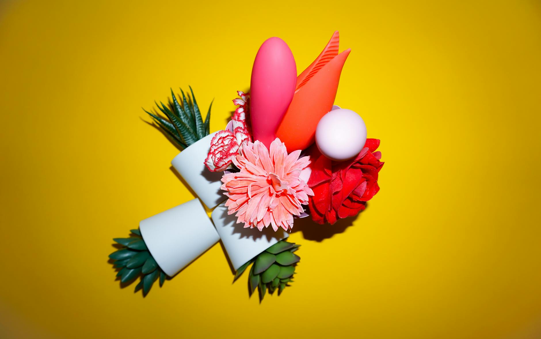 Hand holding a fresh lemon on a soft pink background, surrounded by additional lemons