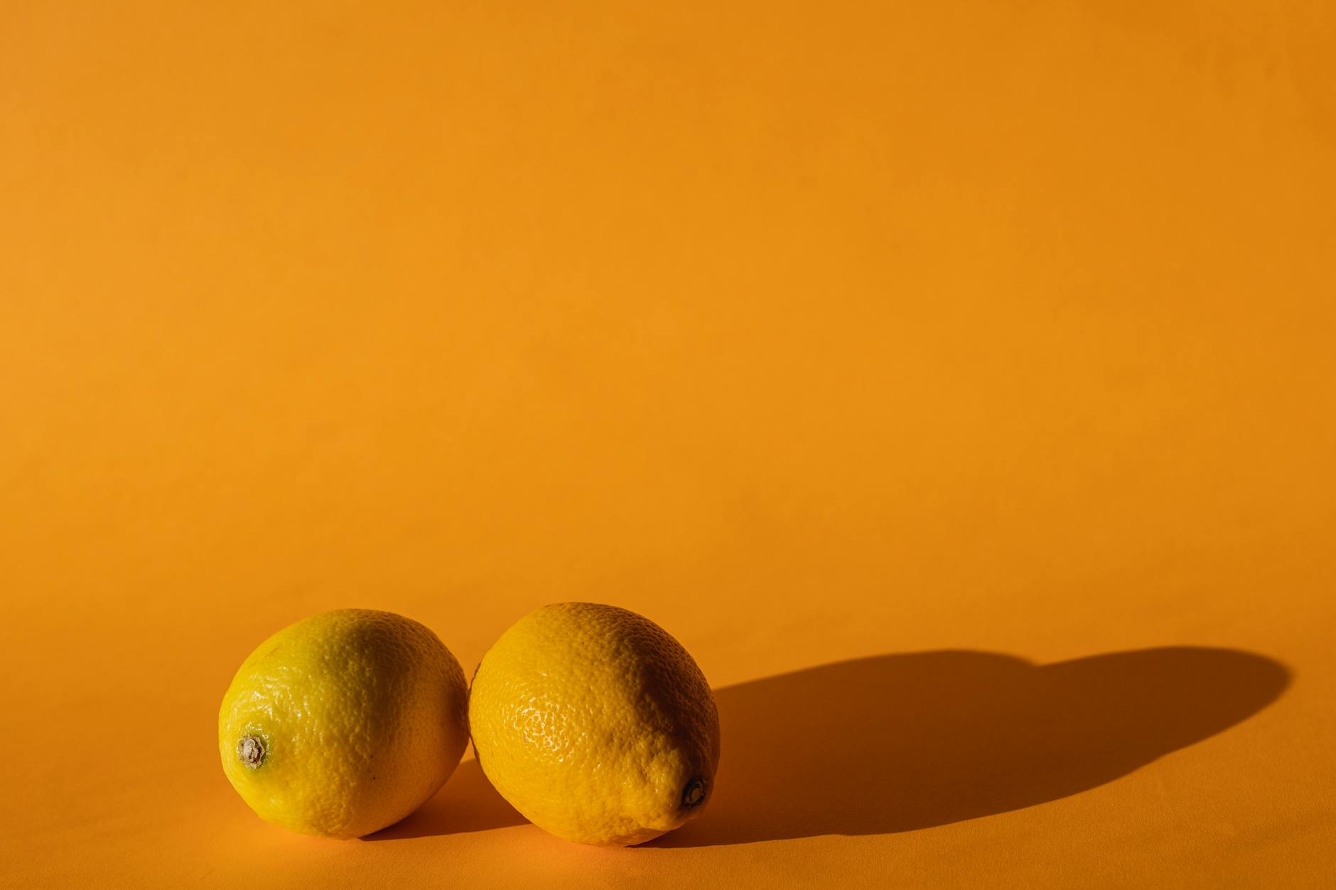 Fresh ripe lemons composed on a bright yellow background, symbolizing direct, intense sensation
